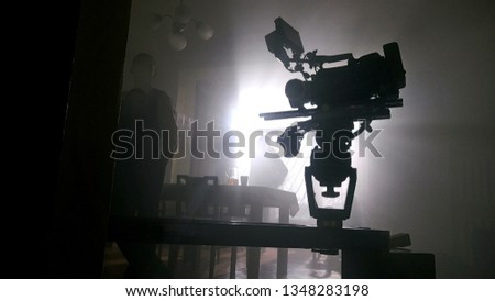 movie camera on the slider in the backlight from the window, the rays of the sun in a smoky room
