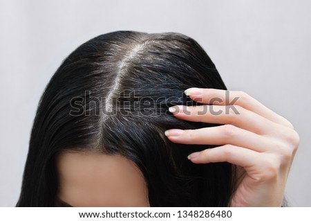 The head of a Caucasian girl with black gray hair. View from above. Close-up. Royalty-Free Stock Photo #1348286480