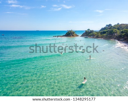 Surfers waiting for a wave at the Pass in Byron Bay with clear blue water. Royalty-Free Stock Photo #1348295177