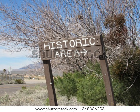View of historic area directional sign.  Desert landscape is visible in the background