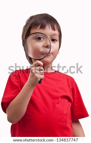 little boy playing with magnifier on white background
