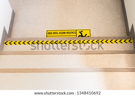 Close up yellow sign caution warning sign mind the step on floor at staircase in the high building.Prevention accident symbol in the office.Risk management concept.