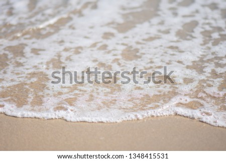beautiful soft wave on sand at the sea sunny day. subject is blurred.