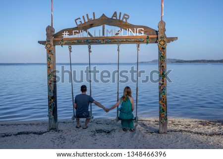 Couple sitting on the swing on gili air