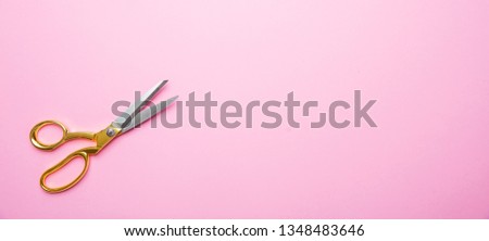 Beauty hair salon concept. Scissors with golden handle on pink background, banner, copy space, top view