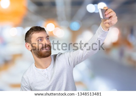 Cheerful young man making photo of himself 