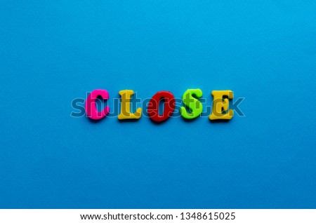 text close from plastic colored letters on blue paper background