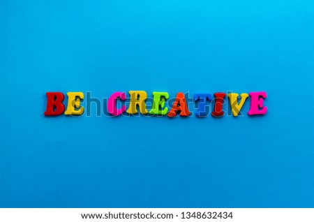 text be creative from plastic colored letters on blue paper background