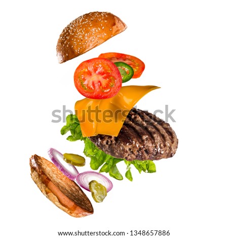 Tasty hamburger with flying ingredients on white background. High resolution image.