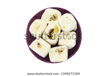 White Turkish delight in purple ceramic plate on isolated white background. Top view of Turkish delight with walnut and peanut.