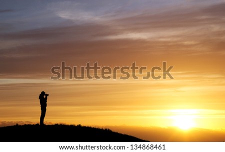 silhouette of photographer in sunset