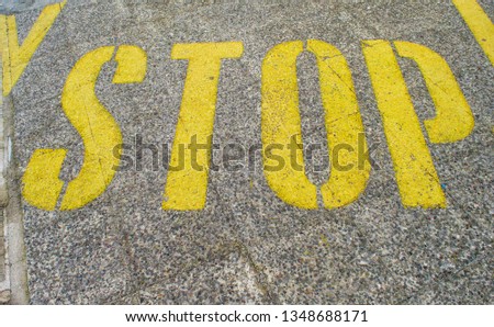 Stop sign painted on asphalt.