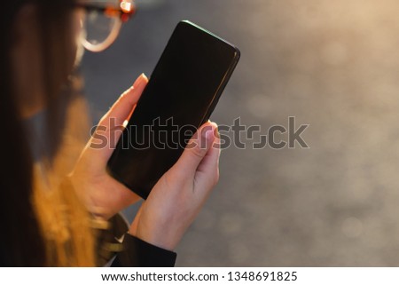 Close-up of female hand using modern smart phone outdoor