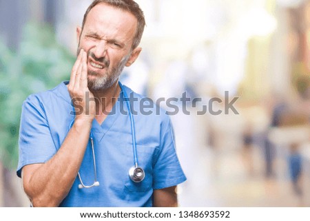 Middle age hoary senior doctor man wearing medical uniform over isolated background touching mouth with hand with painful expression because of toothache or dental illness on teeth. Dentist concept.