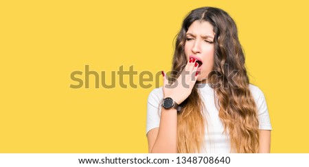 Young beautiful woman wearing casual white t-shirt bored yawning tired covering mouth with hand. Restless and sleepiness.