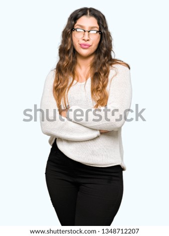 Young beautiful woman wearing glasses skeptic and nervous, disapproving expression on face with crossed arms. Negative person.