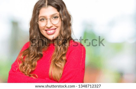 Young beautiful woman wearing red glasses happy face smiling with crossed arms looking at the camera. Positive person.