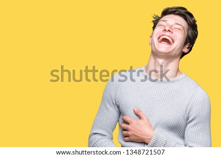 Young handsome man wearing winter sweater over isolated background Smiling and laughing hard out loud because funny crazy joke. Happy expression. Royalty-Free Stock Photo #1348721507