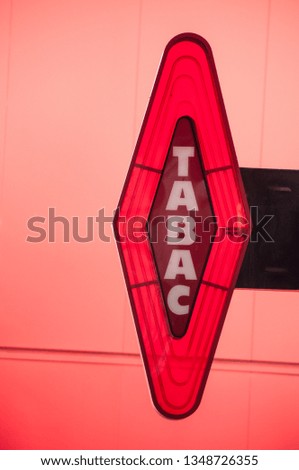 closeup of red tabacco sign on red background with french text tabac, the traduction in english of tobacco 
