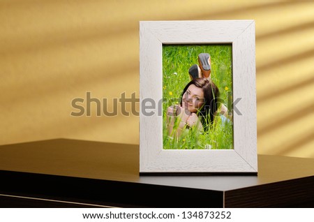 Girls portrait in a photo frame, standing on a table
