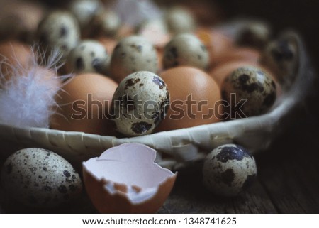 chicken and quail eggs on a dark old kitchen table.