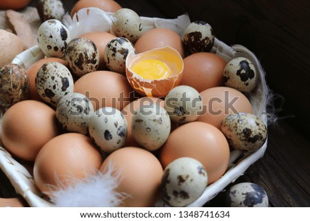 chicken and quail eggs on a dark old kitchen table.