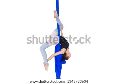 Young girl gymnast hanging on the canvases of fabric in the dance Studio on a white background. Isolate.
