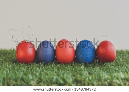 Cute creative photo with easter eggs, some eggs as the Easter Bunny on green background