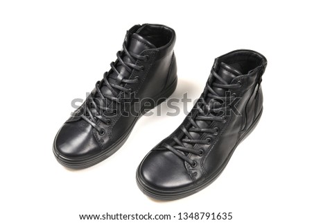 men's black leather shoes and a black camera on a white background. Copy space.