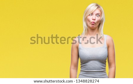 Young beautiful blonde woman over isolated background making fish face with lips, crazy and comical gesture. Funny expression.