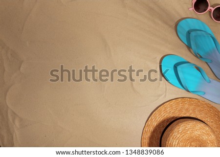 Beach accessories on sand, top view. Space for text