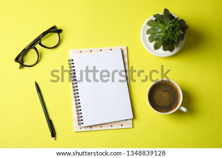 Flat lay composition with notebooks, coffee and plant on color background