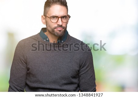 Young handsome man wearing glasses over isolated background skeptic and nervous, frowning upset because of problem. Negative person.