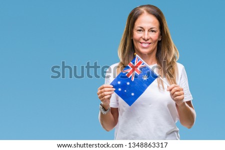 Middle age hispanic woman holding flag of Australia over isolated background with a happy face standing and smiling with a confident smile showing teeth