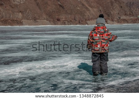 A child walks alone on the ice of Baikal