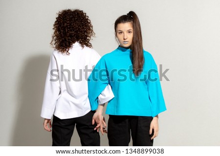 People, youth, leisure and lifestyle concept. Fashionable Caucasian young female student wearing stylish clothing laughing happily, having fun in photo studio. Copy Space