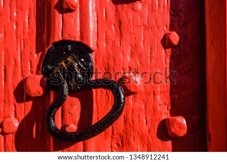 A red church door in East Devon, South West England, United Kingdom.