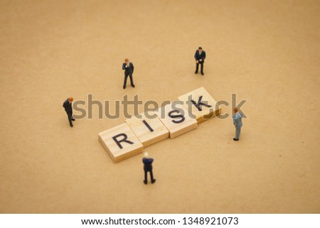 Miniature people businessmen standing with wood word RISK using as background business concept and Risk concept with copy space  for your text or design.