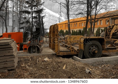 excavators and asphalt paving machine at the construction site in the daytime
