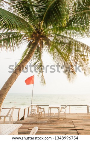 Picturesque sea view wooden terrace at sunset, empty terrace with coconut palm tree and pine tree, a view from the terrace looking at tropical sea, a tranquil scene in summer. Trat, Thailand.