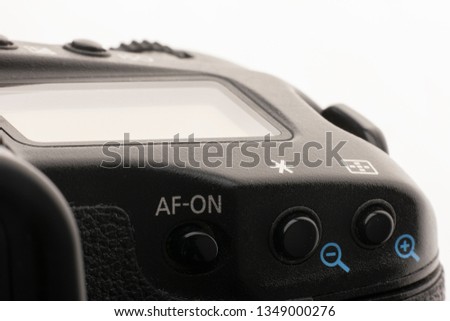 Close-up macro shot of a modern digital SLR camera. Detailed photo of black camera body with a classic wide aperture portrait lens The image can be used as a background.