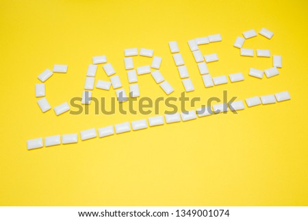 Gum in the form of caries lettering on a yellow background