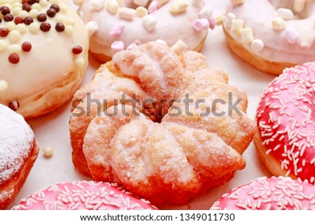 Various types of donuts on pink background. 