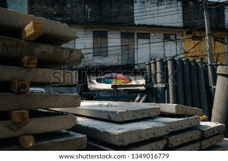 colorful umbrella amidst concrete construction material in Bangkok, Thailand