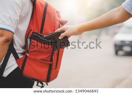 closeup The pickpocket is picking up money from tourists who are traveling. Royalty-Free Stock Photo #1349046845