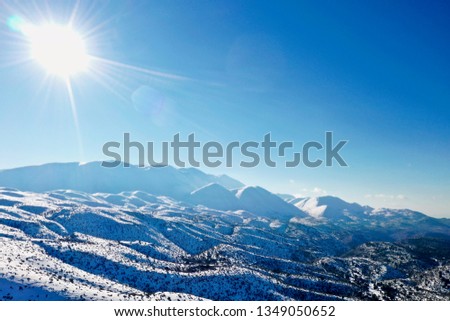 The snowed in Psiloritis mountain of the Mount Ida mountain range, known variously as Idha, Ídhi, Idi, Ita, crete, greece, with blue sky, aerial photography