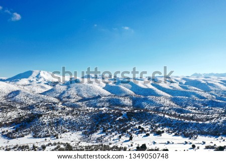 The snowed in Psiloritis mountain of the Mount Ida mountain range, known variously as Idha, Ídhi, Idi, Ita, crete, greece, with blue sky, aerial photography