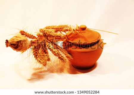 The photo of clay dishes with dry poppy and wheat which can be good picture for home restaurant or café in country style with healthy, eco meal




