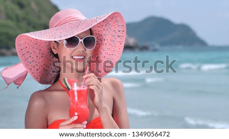Beautiful young Asian women who are happy in bikini with fruit juice, relaxing at sea. Concept Lifestyle, tourism. with copy space