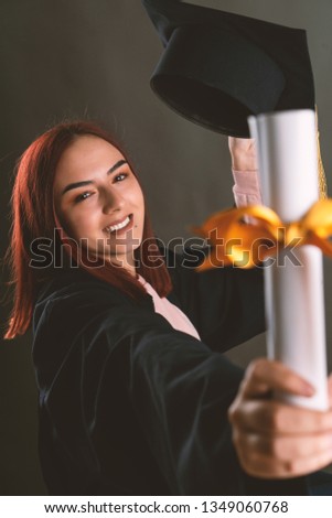 Young blonde woman wearing graduate uniform over isolated background celebrating surprised and amazed for success with arms raised and open eyes. Winner concept